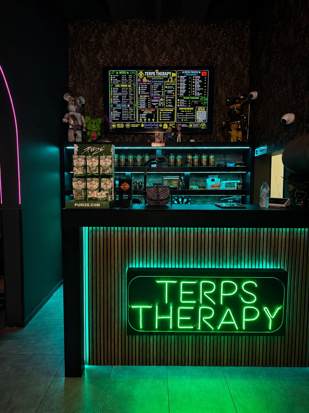 The bar counter at Terps Therapy Barcelona, lit by a green neon sign